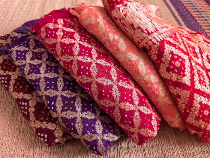 Hand-loomed stack of Khaddi Georgette Saree fused with traditional Tie-Dye Bandhani patterns and gold Zari work.