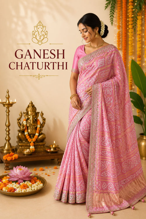 Woman wearing a pink Bandhani silk saree with Ganesh idol and festive marigold decorations.