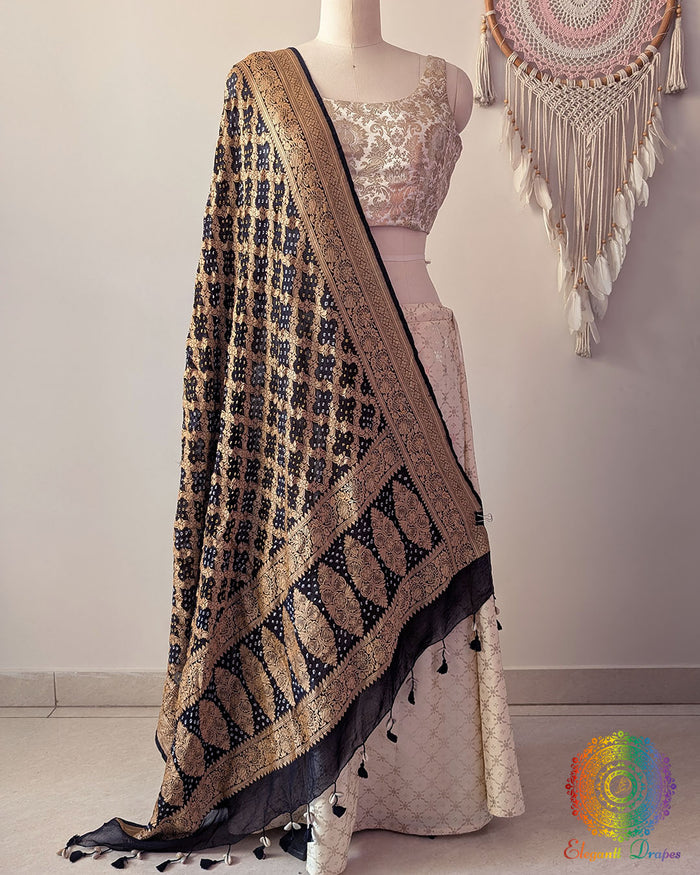 Black Banarasi georgette Gharchola Bandhani dupatta draped on mannequin with zari border and kodi tassels