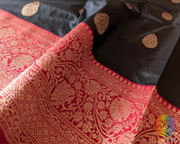 Red border close up on black Banarasi handloom silk saree highlighting woven detail