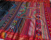 Close up of black and red Ilkal silk saree with Lambani embroidery