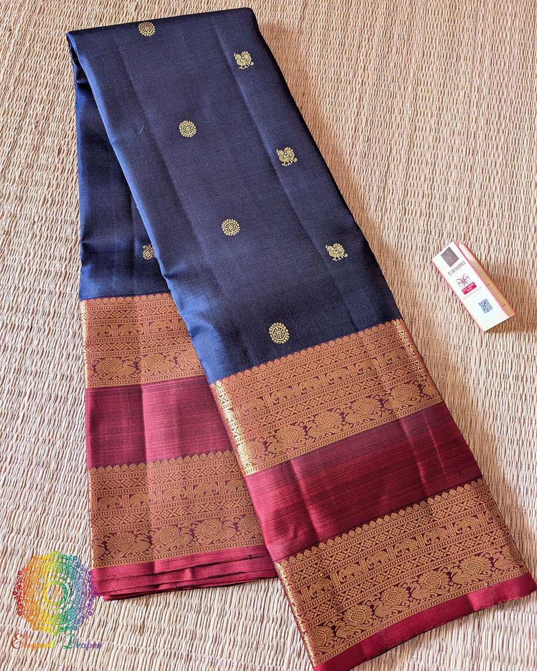 Folded navy blue Kanjivaram silk saree showing red border and 2 gram zari weaving