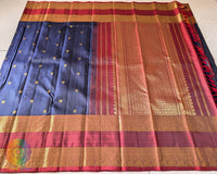 Full navy blue Kanjivaram silk saree laid open showing red palla and woven design