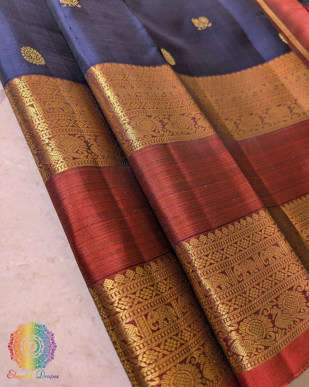 Red border close up on navy blue Kanjivaram silk saree highlighting zari weaving