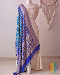 Blue shaded Banarasi georgette Gharchola Bandhani dupatta draped on mannequin with zari border and kodi tassels