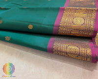 Close up of bottle green Kanjivaram silk saree showing pure silk weave and zari detail