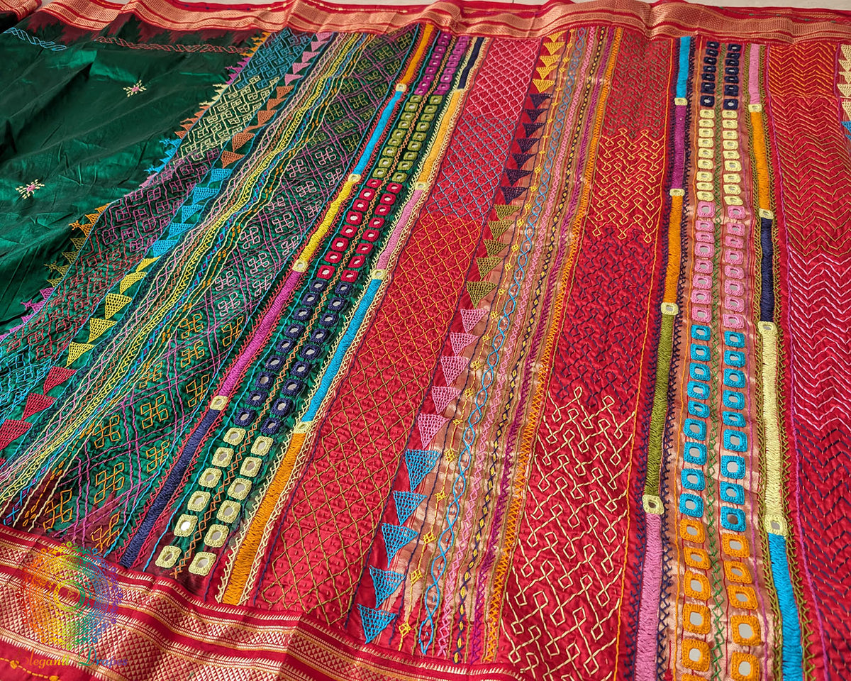 Full view of the Deep Green Pure Ilkal Silk Saree with Sindur Lambani Handwork, highlighting the red palla and border against the deep green body.
