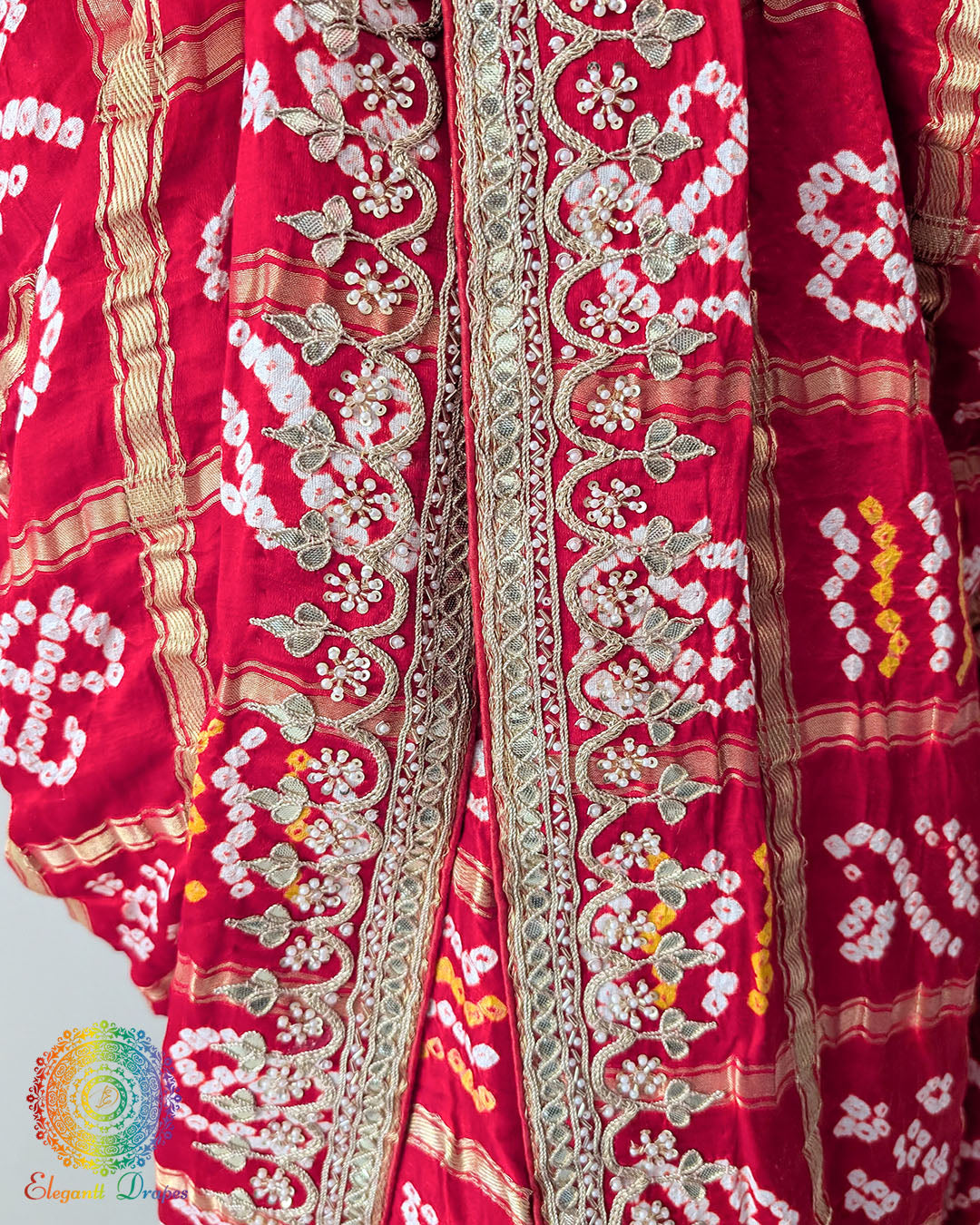 Close-up of the border of the Bridal Red Gaji Silk Gharchola Saree, showcasing the intricate Gota Patti embellishments, traditional design details and rich silk texture.