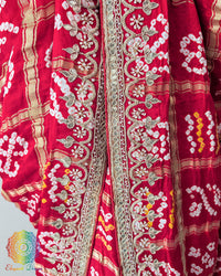 Close-up of the border of the Bridal Red Gaji Silk Gharchola Saree, showcasing the intricate Gota Patti embellishments, traditional design details and rich silk texture.