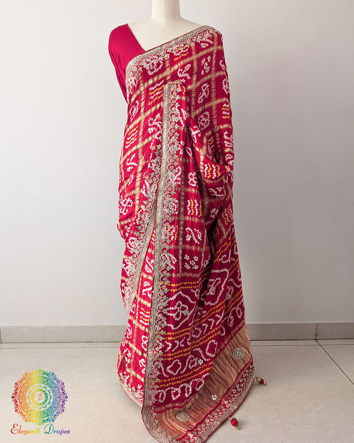 Bridal Red Gaji Silk Gharchola Saree with Gota Patti Work in a front drape view, showcasing the rich bridal red colour, traditional Gharchola design and golden hand embellishments.