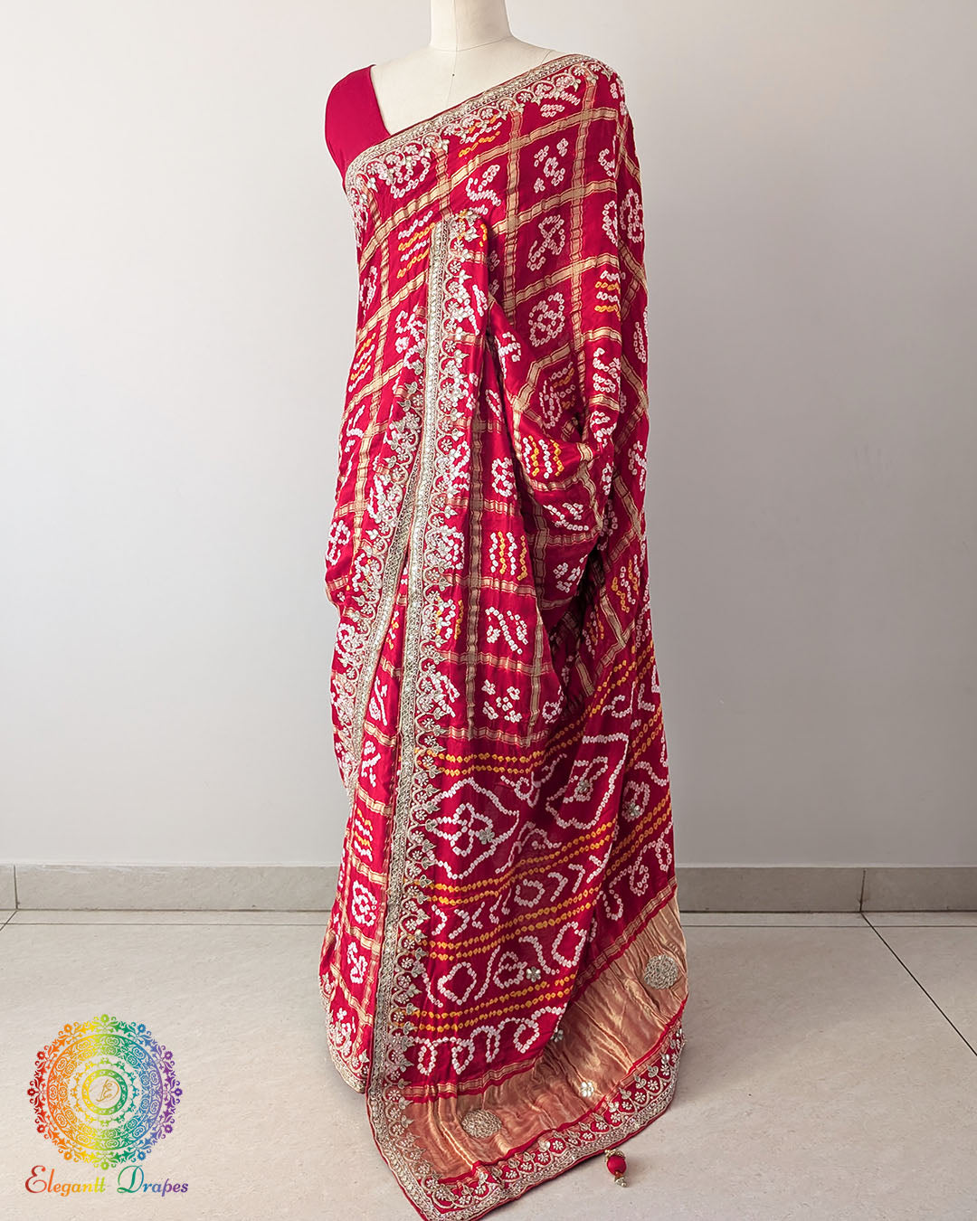 Bridal Red Gaji Silk Gharchola Saree in a side drape view, highlighting the graceful fall of the silk fabric and the intricate Gota Patti detailing.