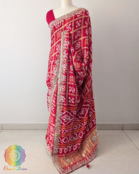Bridal Red Gaji Silk Gharchola Saree in a side drape view, highlighting the graceful fall of the silk fabric and the intricate Gota Patti detailing.