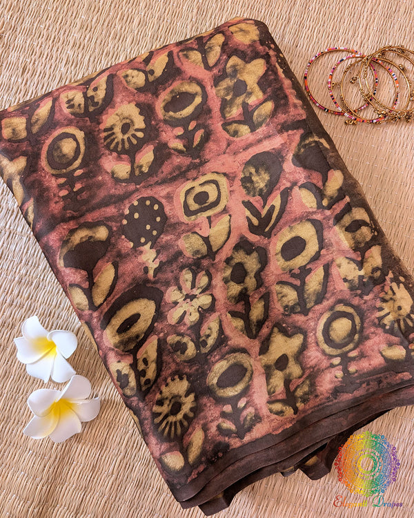 Brown Nashpal Pomegranate Ajrakh Modal Tussar Saree folded to display the rich brown colour, pomegranate-inspired Ajrakh pattern and printed fabric details.