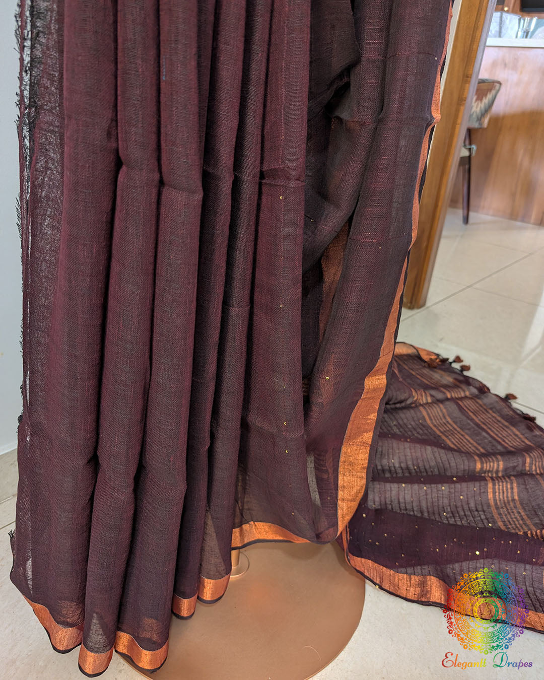 Pleats detail of coffee brown linen saree showing texture and fall