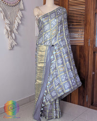 Deep grey gaji silk saree on mannequin showcasing Gharchola pattern detail
