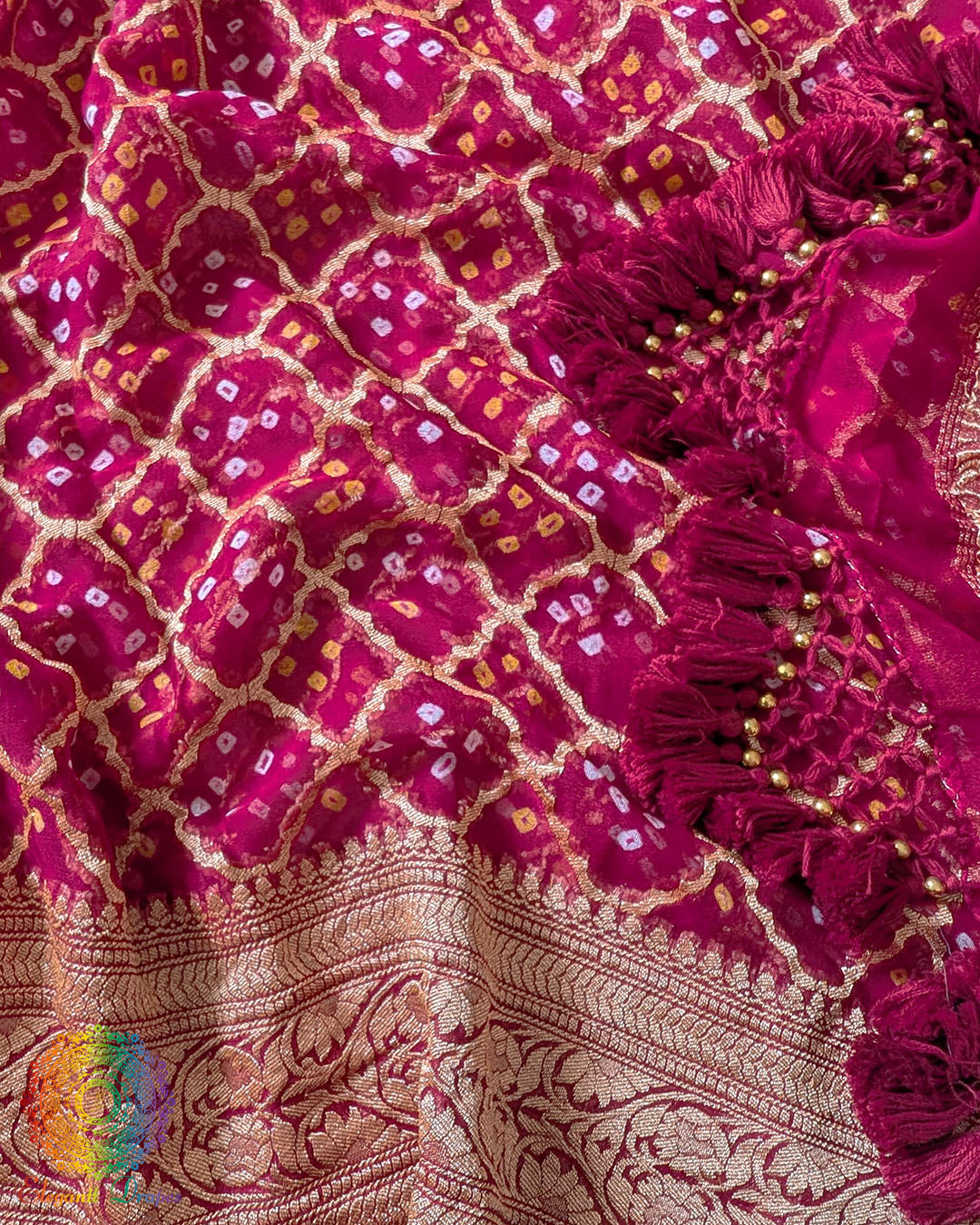 Close up of traditional Bandhani motifs on the deep magenta Khaddi georgette Banarasi saree