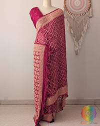Deep magenta Khaddi georgette Banarasi Bandhani saree on mannequin showing full drape and handcrafted tassels