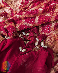 Close-up of traditional kodi tassels, zari border, and Bandhani motifs on deep red Banarasi georgette Gharchola Bandhani dupatta