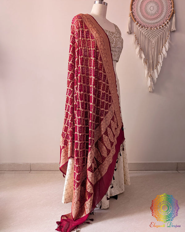 Side view of deep red Banarasi georgette Gharchola Bandhani dupatta showcasing elegant drape, Gharchola checks, and Bandhani motifs