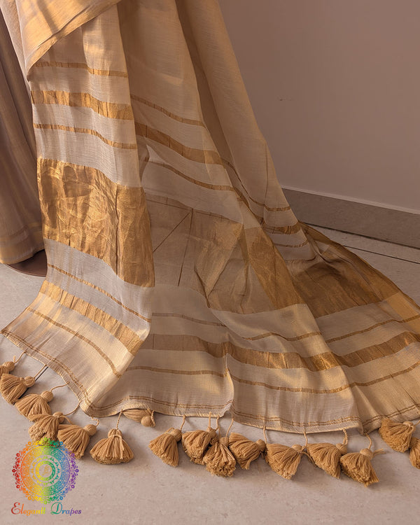 Close up of golden bengal tissue linen saree showing fabric texture and pom pom work