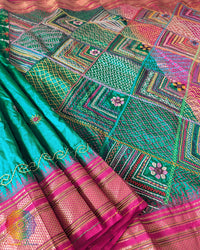 Emerald green pure Ilkal silk saree laid open showing pink palla and border