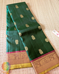 Folded green Kanjivaram silk saree showing red border and 2 gram zari weaving