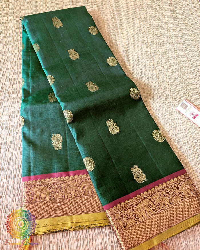 Folded green Kanjivaram silk saree showing red border and 2 gram zari weaving