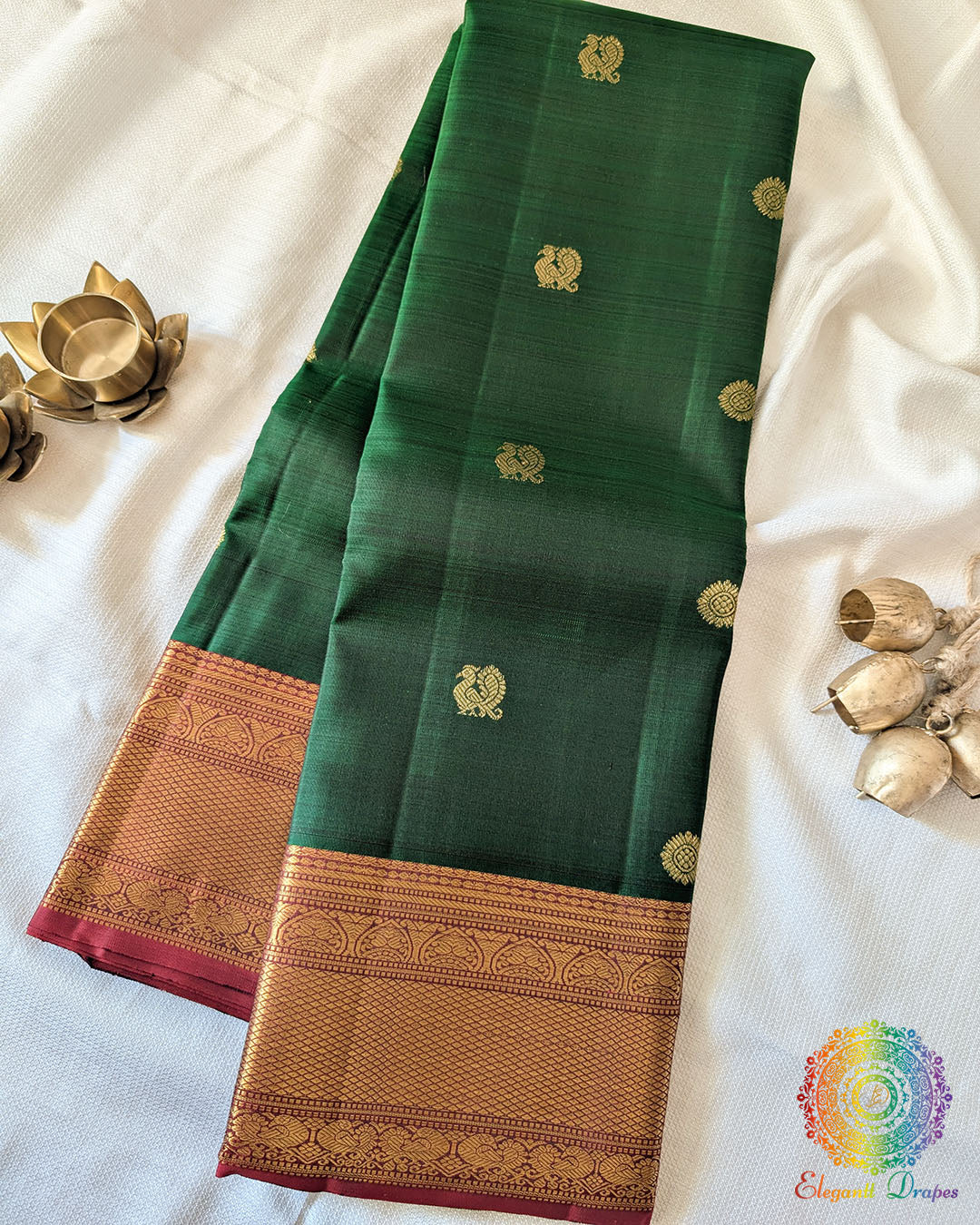 Green Pure Kanjivaram Handloom Silk Saree with 1gm Gold Zari displayed in a folded view, showcasing the rich green silk fabric and traditional golden zari detailing.