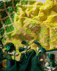 Close-up of traditional kodi tassels, zari border, and Bandhani motifs on green shaded Banarasi georgette Gharchola Bandhani dupatta