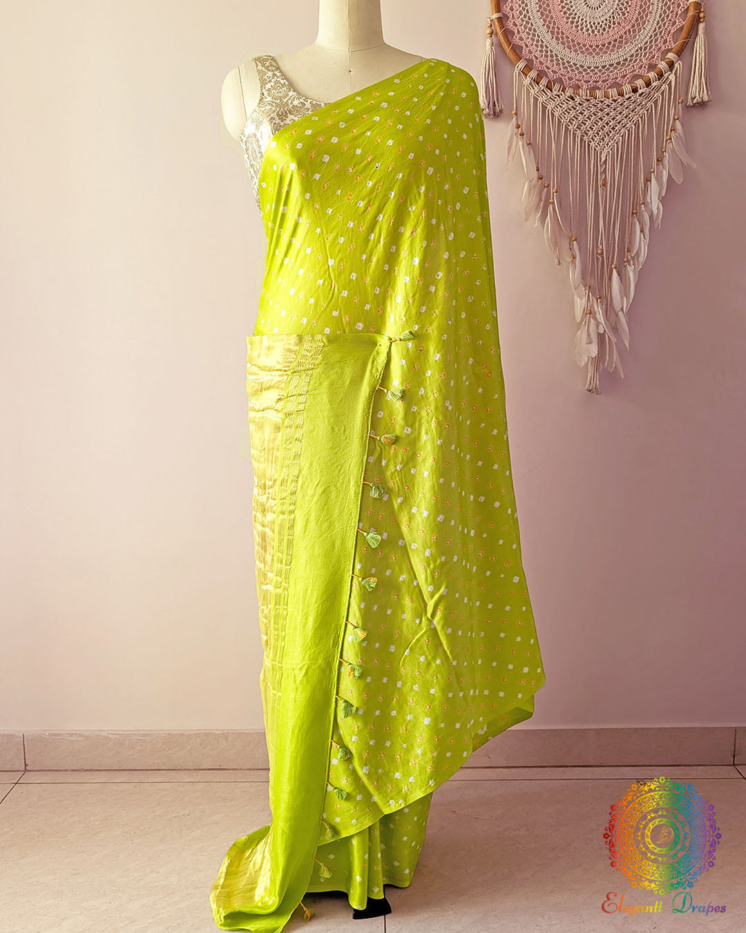 Lime green gaji silk saree on mannequin showcasing traditional bandhani dots
