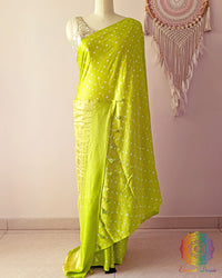 Lime green gaji silk saree on mannequin showcasing traditional bandhani dots