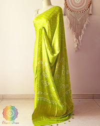 Side angle view of lime green bandhani saree highlighting fluid silk drape