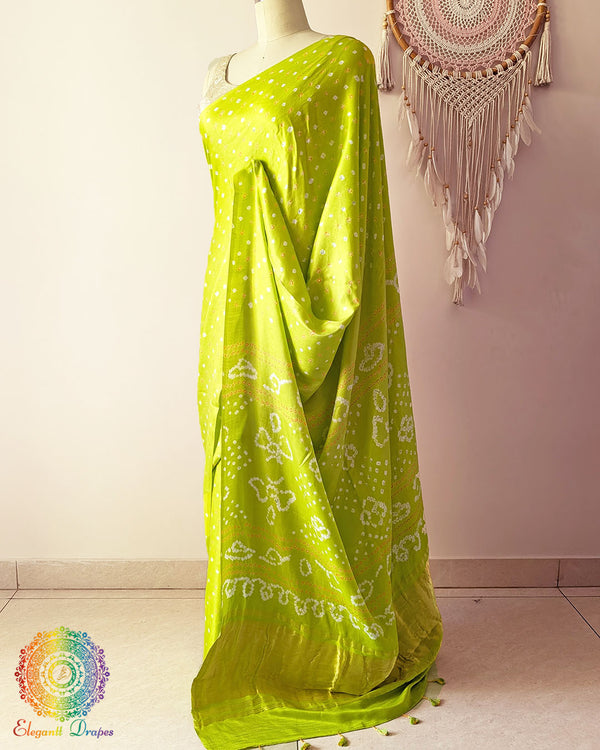 Side angle view of lime green bandhani saree highlighting fluid silk drape