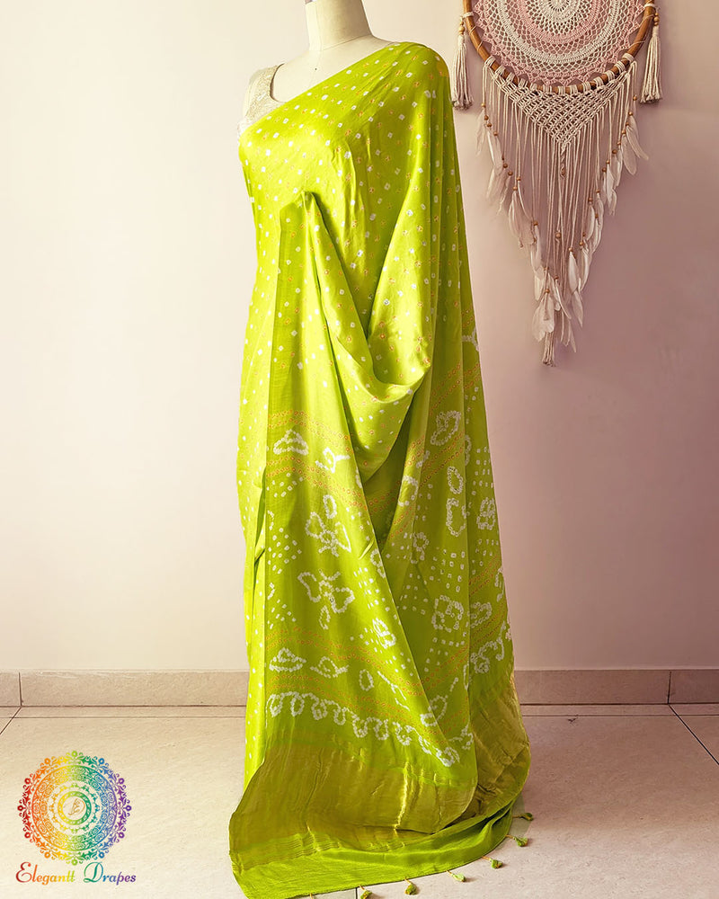 Side angle view of lime green bandhani saree highlighting fluid silk drape