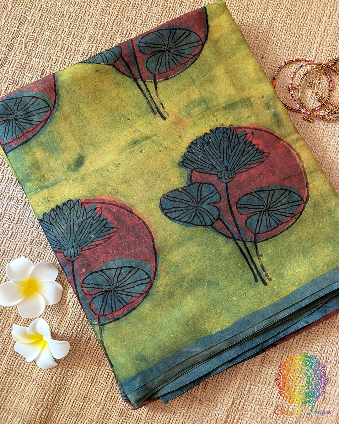 Lime Green Nashpal Pomegranate Ajrakh Modal Tussar Saree folded to display its fresh green shade and distinctive floral Ajrakh print.