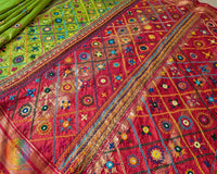 Close-up of the Lime Green Pure Ilkal Silk Saree showcasing Sindur Lambani handwork, highlighting the intricate thread embroidery against the bright green silk fabric.