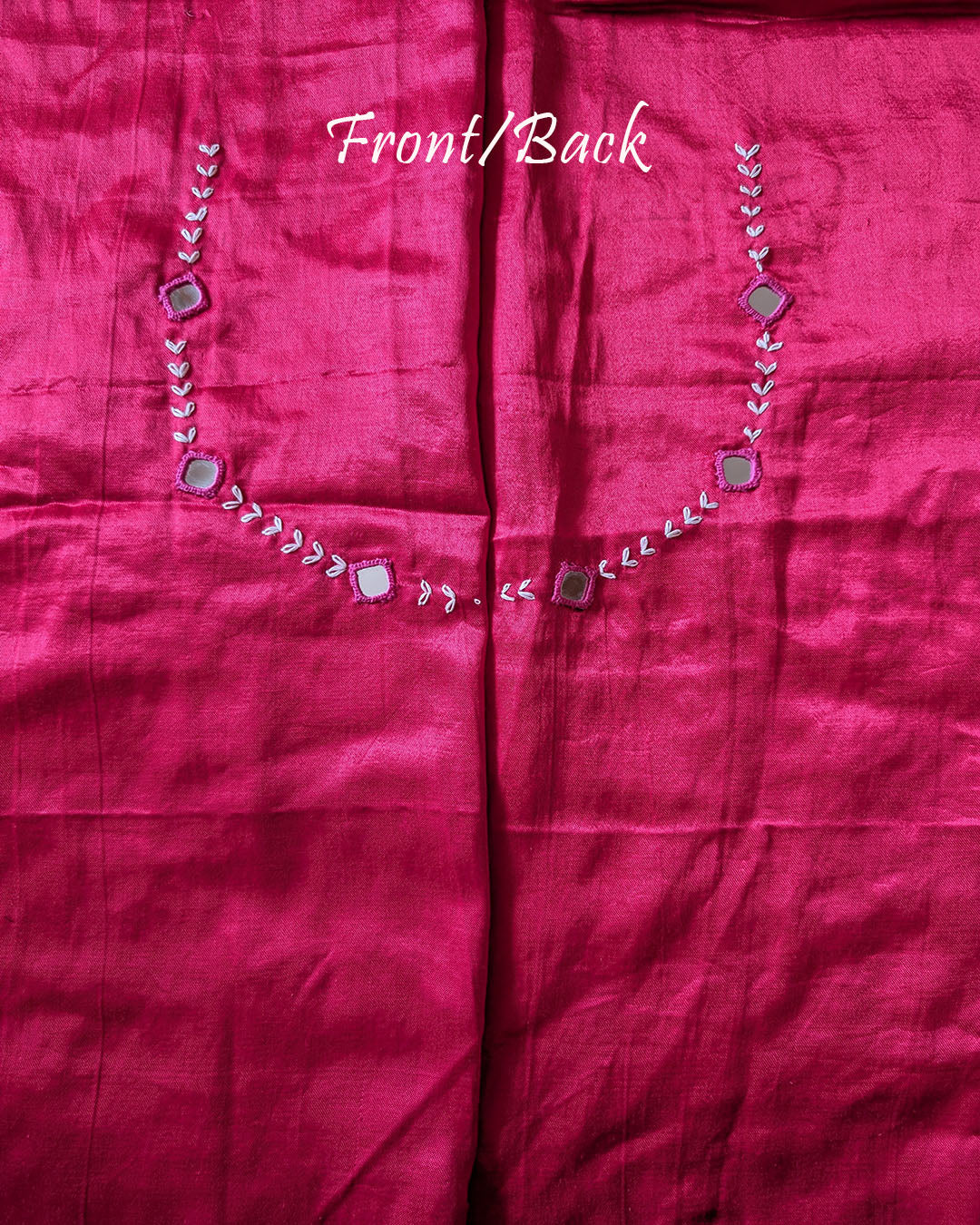 Back view of rani pink Mashru silk blouse piece highlighting handcrafted mirror embroidery