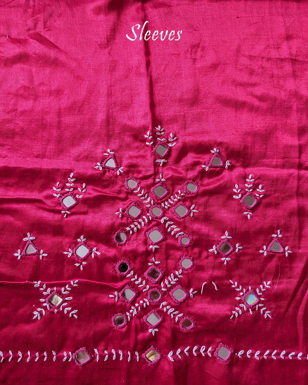 Sleeve detail of rani pink Mashru silk blouse piece featuring traditional Kutch mirror work