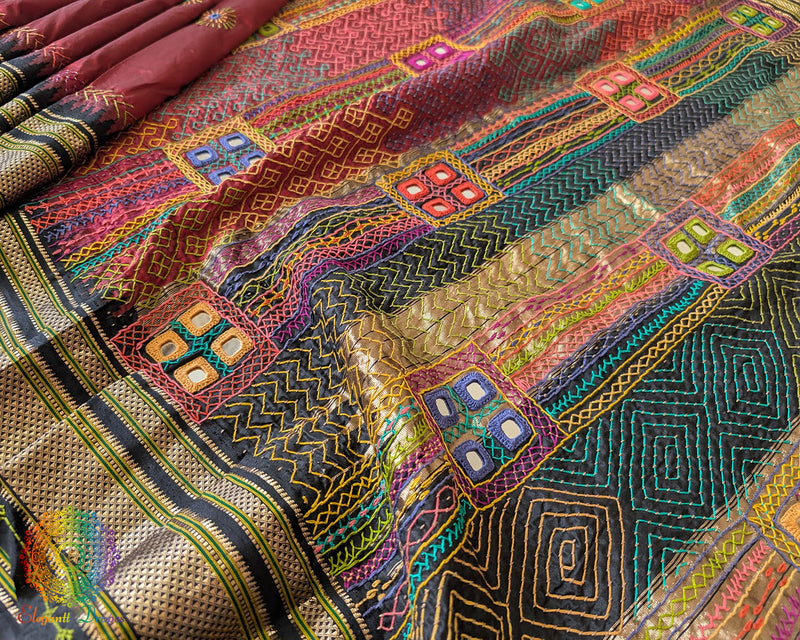 Black palla close up on maroon Ilkal saree showcasing Lambani embroidery