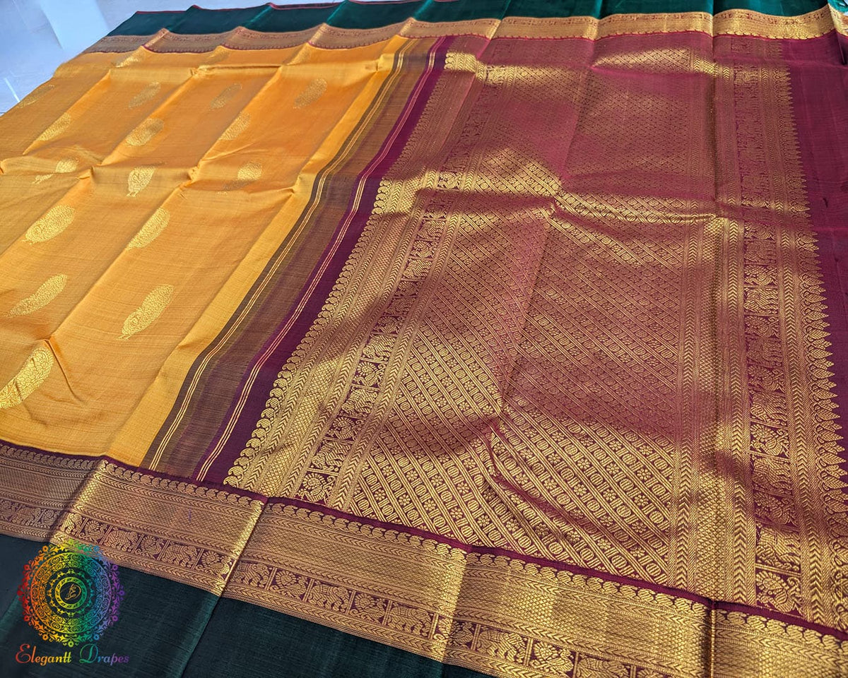 Mustard Kanjivaram silk saree pallu view with green border and zari work