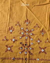 Sleeve detail of the Mustard Kala Cotton Kutch Mirror Handwork blouse piece, highlighting the real mirror embellishments, intricate threadwork and warm mustard cotton fabric.