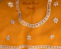 Mustard Orange Organza Leheria Saree – Blouse back view featuring the coordinated Organza fabric and matching traditional detailing