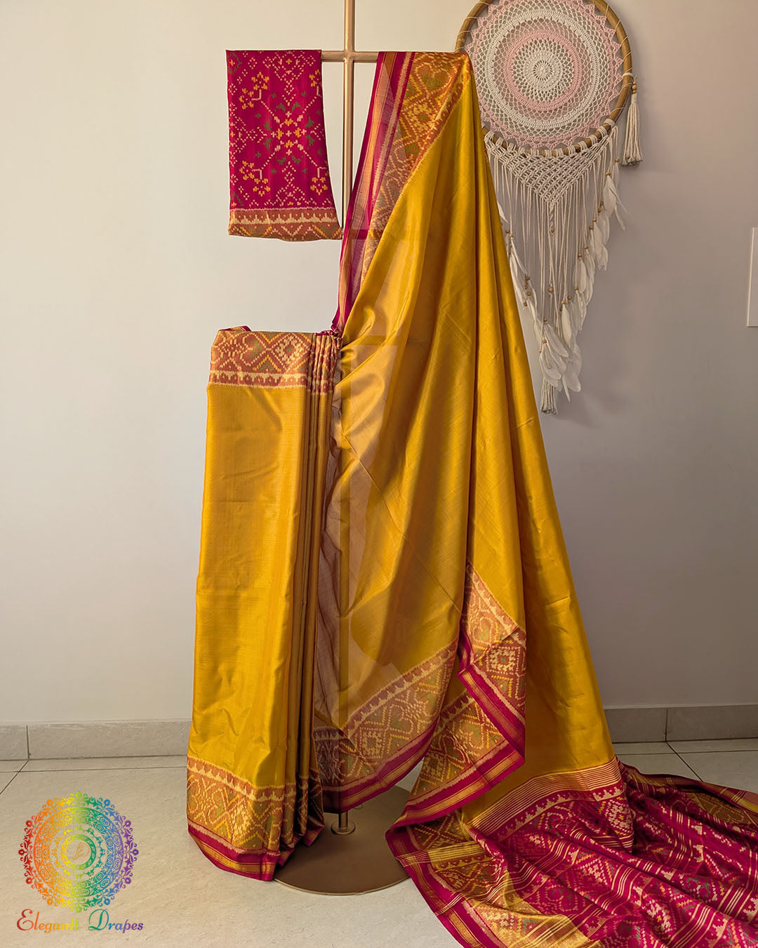Mustard handwoven mulberry silk Rajkot Patola saree on mannequin showing red palla and full drape