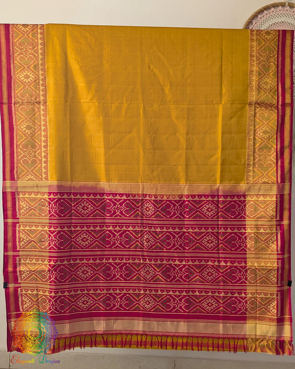 Open palla view of mustard Rajkot Patola pure mulberry silk saree displaying red palla and woven design