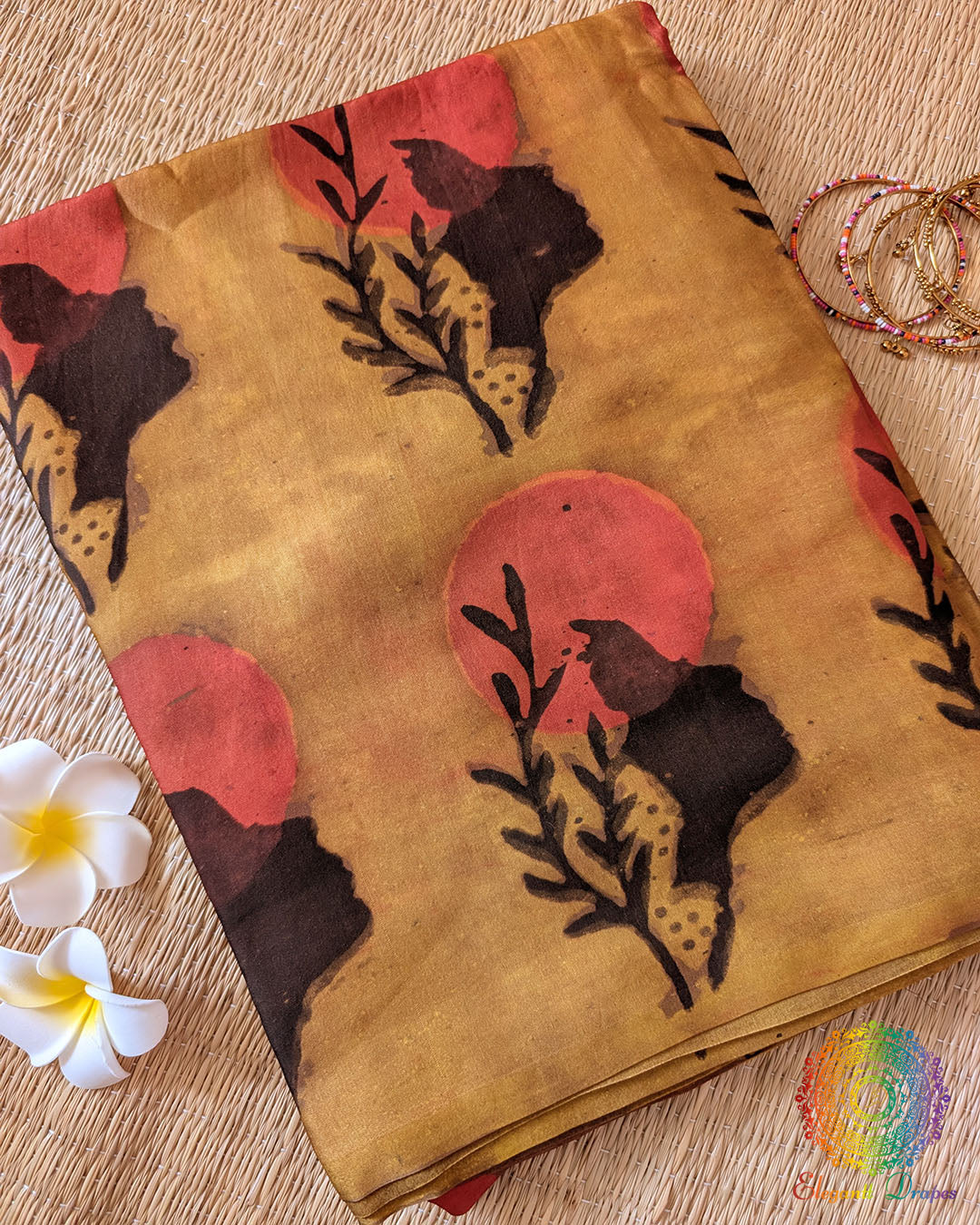 Yellow Nashpal Pomegranate Ajrakh Modal Tussar Silk Saree folded to display its bright yellow shade, pomegranate Ajrakh print and distinctive striped design.