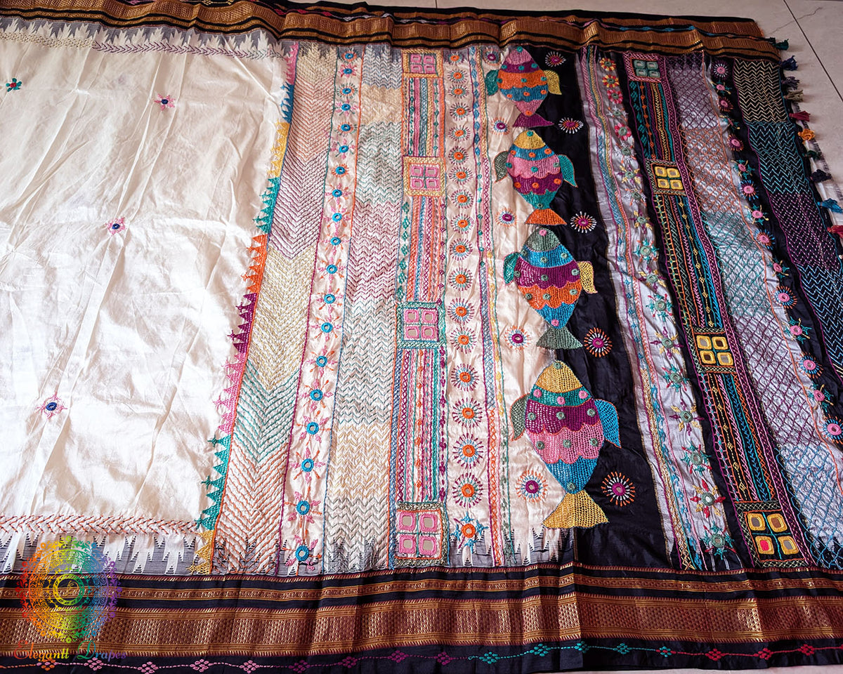 Off white black pure Ilkal silk saree laid flat showcasing Lambani hand embroidery
