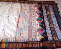 Off white black pure Ilkal silk saree laid flat showcasing Lambani hand embroidery