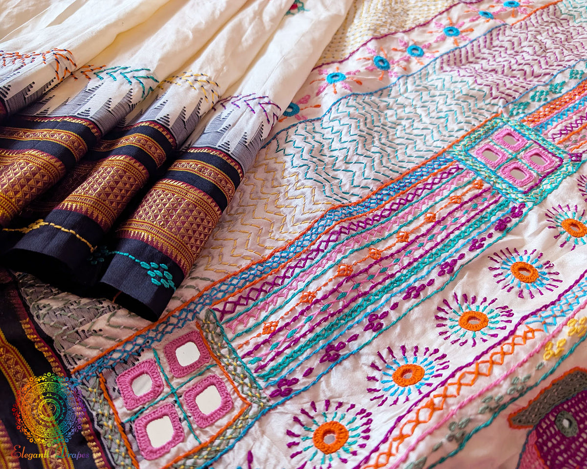 Detailed view of handcrafted Lambani embroidery on off white Ilkal silk saree