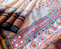 Detailed view of handcrafted Lambani embroidery on off white Ilkal silk saree