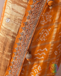 Detailed view of handcrafted gota patti embellishment on orange Gharchola saree